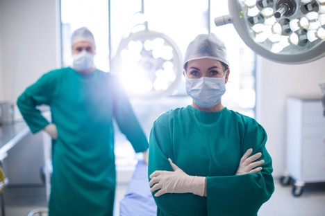 surgical assistants in front of surgical lights
